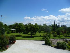 um jardim com um parque com árvores e um banco em Appartamento in villa em Fano