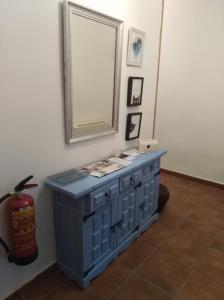 niebieska szafka w pokoju z lustrem w obiekcie CASA RURAL ALAJÚ w mieście Villalba de la Sierra