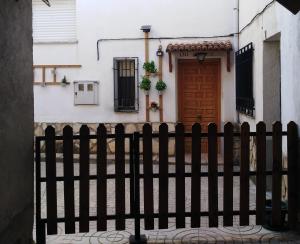 una cerca negra frente a una casa blanca en CASA RURAL ALAJÚ, en Villalba de la Sierra