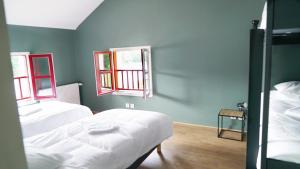 een slaapkamer met 2 bedden en 2 ramen bij MARA RIVIERE Gîte d'étape sur la Vélo Francette in La Jaille-Yvon