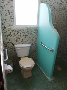 a bathroom with a toilet and a blue bath tub at Bungalows pacíficos in Zihuatanejo +49 photos