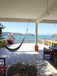 a hammock on a patio with a view of the ocean at Bungalows pacíficos in Zihuatanejo