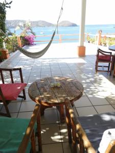 a wooden table and chairs on a patio with the ocean at Bungalows pacíficos in Zihuatanejo +49 photos