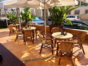 a patio with tables and chairs and umbrellas at Hostal Juan Carlos in Carboneras