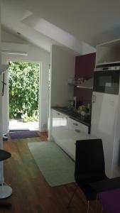 une cuisine avec des placards blancs et une porte donnant sur une cour. dans l'établissement The Garden House, à Lund