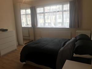 sypialnia z łóżkiem i dużym oknem w obiekcie Gladstone Lodge Guest House w Londynie