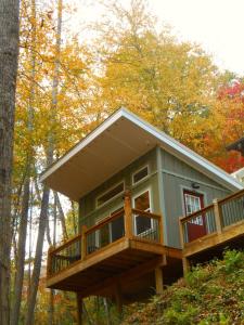 a tree house with a deck in the woods at The Owl's Perch in Robbinsville