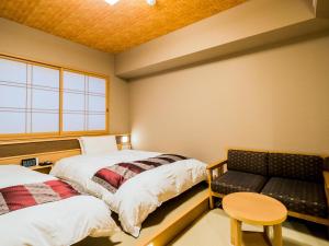 a room with a bed, chair, desk and a lamp at Onyado Nono Namba Natural Hot Spring in Osaka