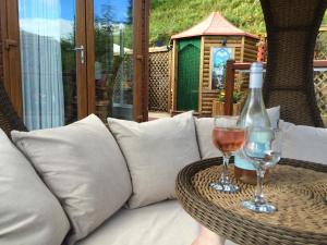 a bottle of wine and two glasses on a table at Ramintoul Lodge in Glendevon