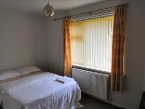 a bedroom with a bed and a window at Spacious semi detached house in Leigh