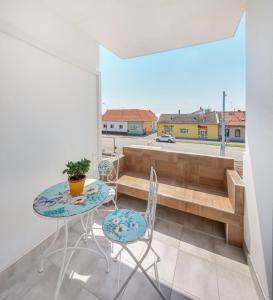 a room with a table and chairs and a balcony at Apartman Osijek in Osijek