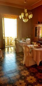 a dining room with tables and chairs and a chandelier at Casa Tonina in Carloforte