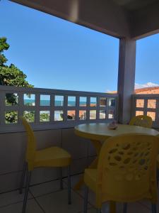 balcón con mesa y sillas amarillas en Casa Temporada Maragogi, en Maragogi