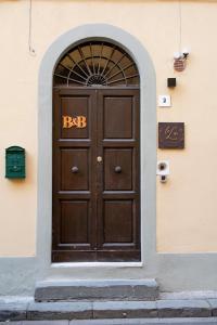 uma porta de madeira com um sinal de saída num edifício em La Lu cozy rooms - Self check-in em Pisa