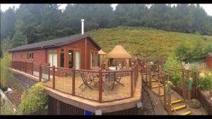 Ramintoul Lodge في Glendevon: منزل صغير مع ملعب أمام تلة
