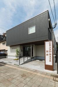 a building with a sign in front of it at GRAND BASE Beppu in Beppu