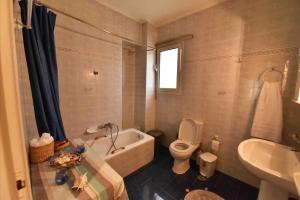 a bathroom with a tub and a toilet and a sink at Sea View Apartment in Chalkida
