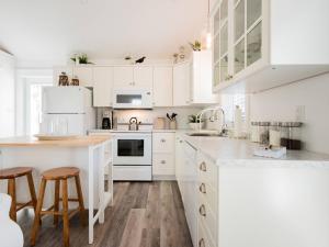 a white kitchen with white cabinets and wooden floors at Mahone Bay Hide-Away in Mahone Bay