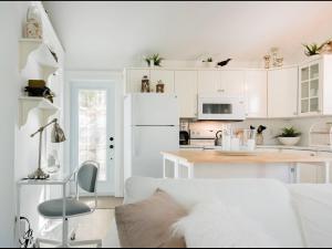 a white kitchen with white cabinets and a white couch at Mahone Bay Hide-Away in Mahone Bay