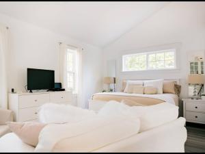 a white living room with two beds and a couch at Mahone Bay Hide-Away in Mahone Bay