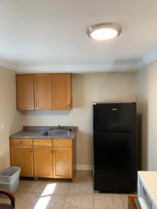 a kitchen with a black refrigerator and wooden cabinets at A-1 Budget Motel in Klamath Falls