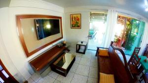 a living room with a flat screen tv on the wall at Pousada da Baleia in Rio das Ostras +66 photos