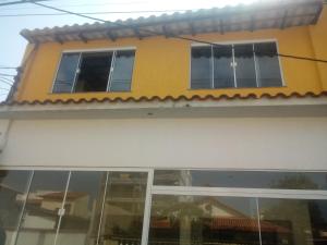 żółto-biały dom ze szklanymi oknami w obiekcie Recanto Saqua w mieście Saquarema