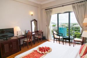 a bedroom with a bed and a desk and a television at Seagull Hotel in Quy Nhon