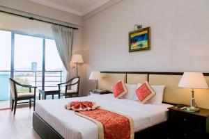 a hotel room with a bed and a balcony at Seagull Hotel in Quy Nhon