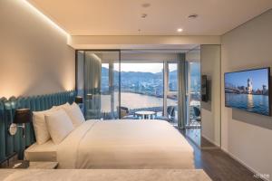 a hotel room with a large bed and a large window at Lavalse Hotel in Busan