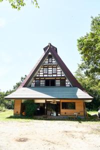 a large house with a gambrel roof at Guesthouse Kazura in Nanto