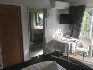 a room with a bed, table and a window at Sandy Feet Accommodation in Christchurch
