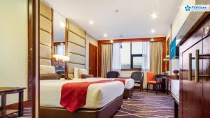 Cette chambre comprend deux lits et un bureau. dans l'établissement Cebu Parklane International Hotel, à Cebu