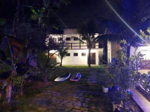 two surfboards sitting in the yard of a house at night at Espaço Aba Maranata in Ubatuba