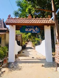 a sign for an ooptuffs hotel on a building at Cocohuts Hotel in Karimunjawa