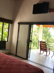 a bedroom with a bed and a sliding glass door at Villas Lambeau Ocean View 1 in Uvita