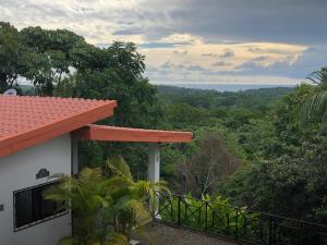 a house with a balcony and a view of the forest at Villas Lambeau Ocean View 1 in Uvita