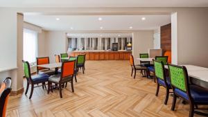 una sala da pranzo con tavoli e sedie e una cucina di SureStay Hotel by Best Western Florence a Florence