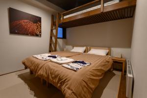 Un pat sau paturi într-o cameră la Tanuki Nozawa