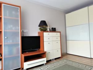 a living room with a tv and a dresser with a television at Mieszkania na wydmach in Dziwnów