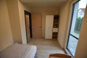 1 dormitorio con cama y ventana grande en Azur apartman, en Balatonfüred
