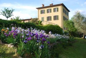 a house with a garden of flowers in front of it at La Foresteria Montecatini Golf in Lamporecchio