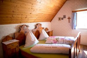 a bedroom with two beds and a wooden ceiling at Roatmoaralm Almhütte in Rachau