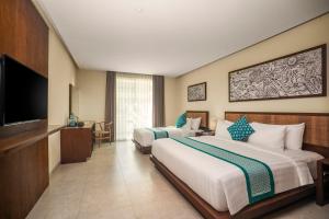 a hotel room with two beds and a flat screen tv at Anja Jimbaran in Jimbaran