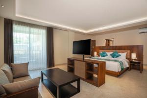 a hotel room with a bed and a couch at Anja Jimbaran in Jimbaran