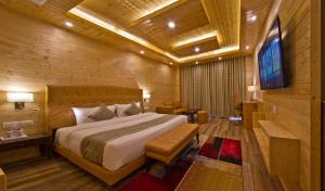 ein Schlafzimmer mit einem Bett und einem TV in einem Zimmer in der Unterkunft The Holiday Villa Resorts & Spa in Manali