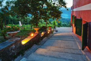 uma passarela com luzes num jardim ao lado de um edifício em Agriturismo Cerrolungo em La Spezia