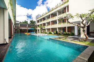 a swimming pool in front of a building at Anja Jimbaran in Jimbaran