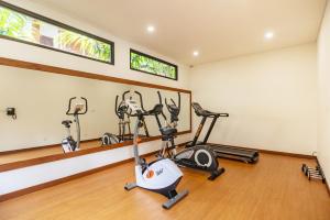 a gym with several exercise bikes in a room at Anja Jimbaran in Jimbaran