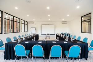 a meeting room with a long table and blue chairs at Anja Jimbaran in Jimbaran +37 photos